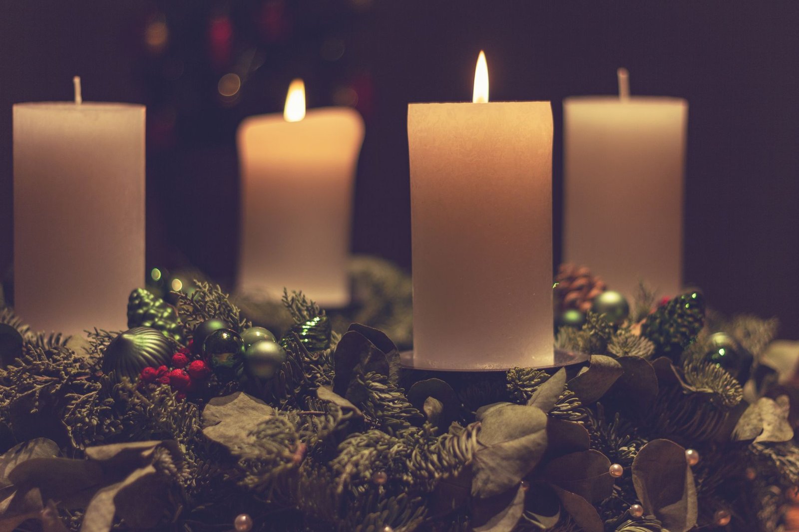 Vier brennende Kerzen auf einem Adventskranz als ruhiges Adventsritual