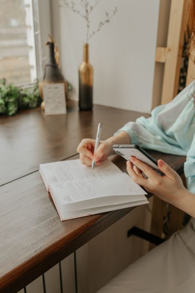 Frau schreibt ihre Gedanken in ein Notizbuch